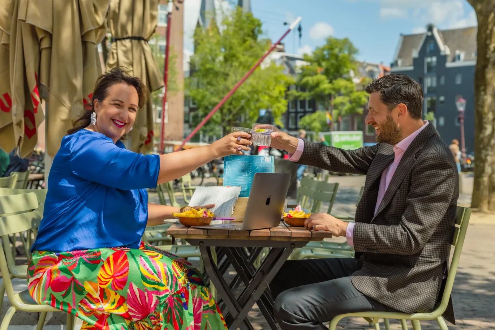 Raquel proost met een klant op een zonnig terras